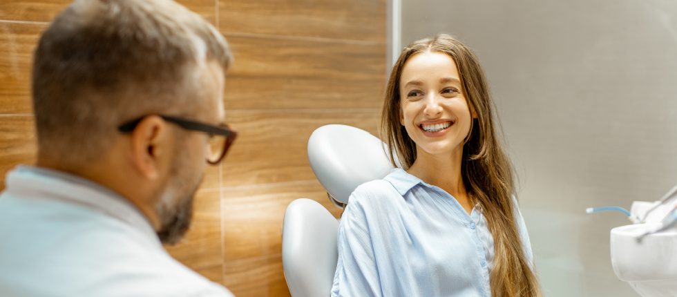 Dentist talking to smiling dental patient