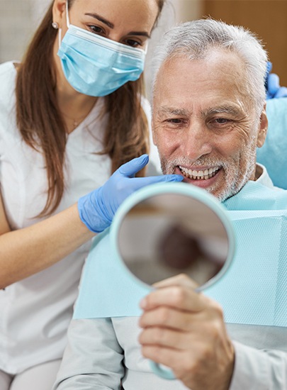 Man looking at attractive smile after metal free dental restorations