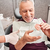 patient holding his bottom denture in the chair