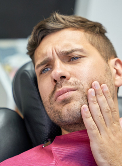Patient with toothache sitting in treatment chair