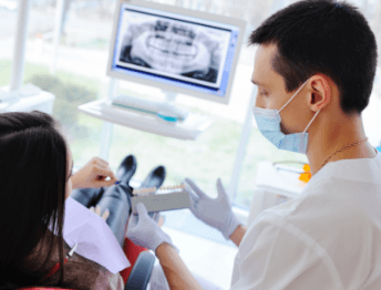 Dentist showing patient replacement teeth