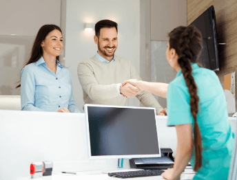 receptionist greeting patients with a smile
