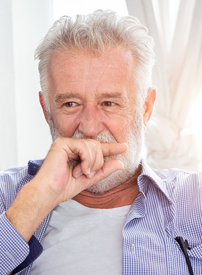 Man in need of tooth extraction covering his mouth