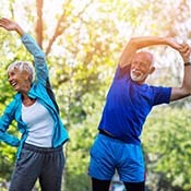 senior man and woman stretching outside 