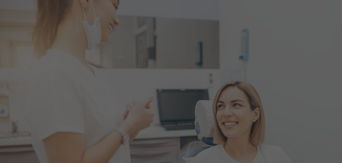 Woman in dental chair smiling at dentist