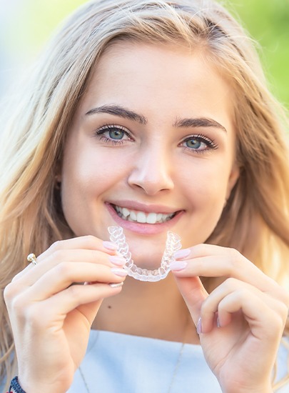 Smiling woman placing her Invisalign tray