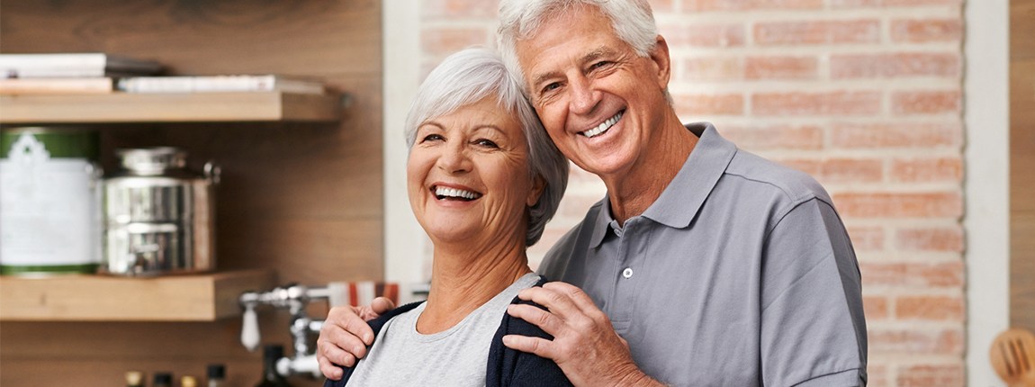 Man and woman with healthy smiles after gum disease treatment