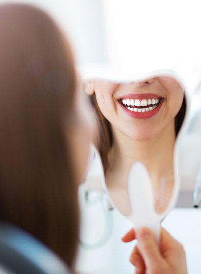 Woman looking at healthy smile after fluoride treatment