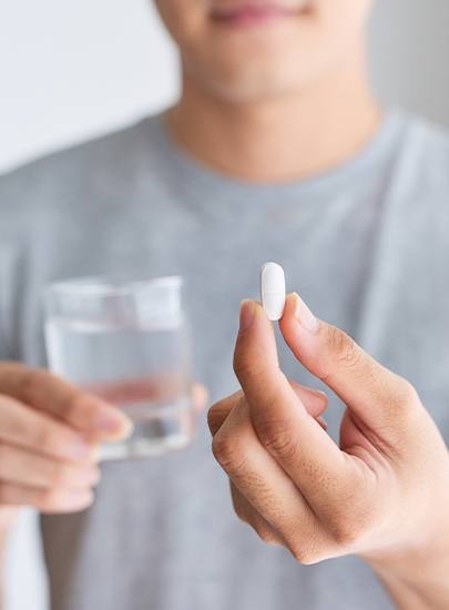 Patient holding an oral conscious dental sedation pill