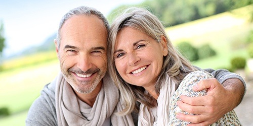 Man and woman with healthy smiles after restorative dentistry