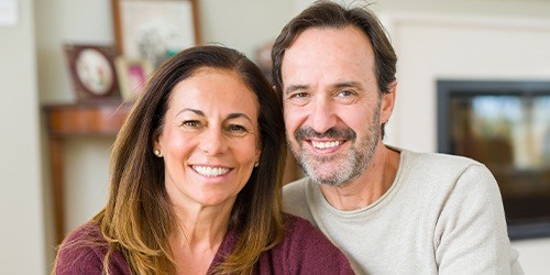 Man and woman with healthy smiles after periodontal therapy