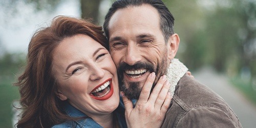 Man and woman laughing together after sedation dentistry visit