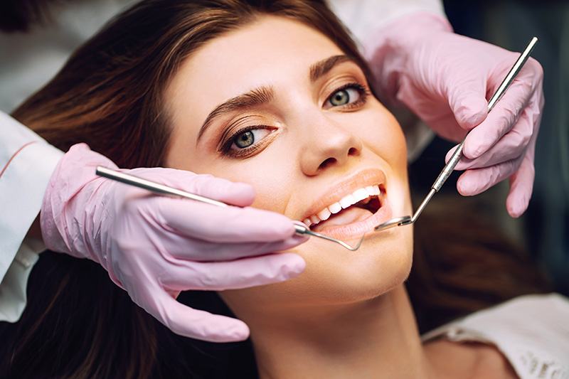 Patient smiling while looking at reflection in dentist's mirror