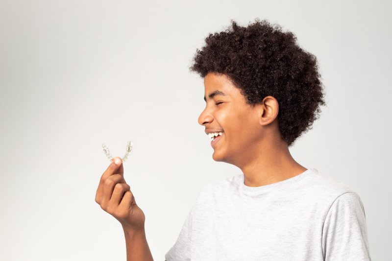 teenager holding Invisalign aligner