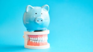 light blue piggy bank sitting atop dentures