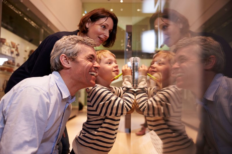 A family looking at a display of ancient cosmetic dentistry in a museum.