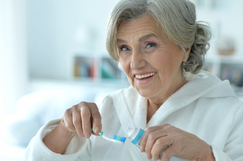 Patient cleaning their dentures due to denture odors