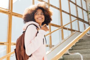 Teen girl smiling and walking upstairs.